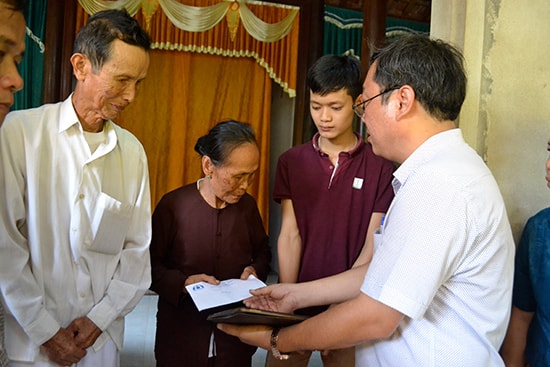 Ông Lê Văn Sinh (người cầm sổ tay) trao tiền hỗ trợ cho gia đình nạn nhân và động viên cha mẹ có 2 con trai bị tử vong. 