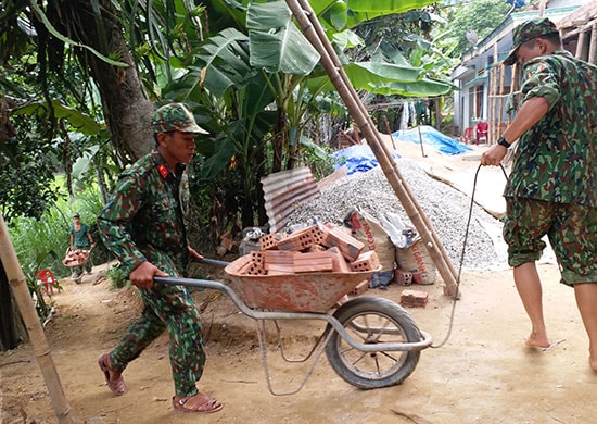 Cán bộ, chiến sĩ Lữ đoàn Tăng thiết giáp 574 Quân khu 5 giúp dân vận chuyển vật liệu. Ảnh: THIÊN THU