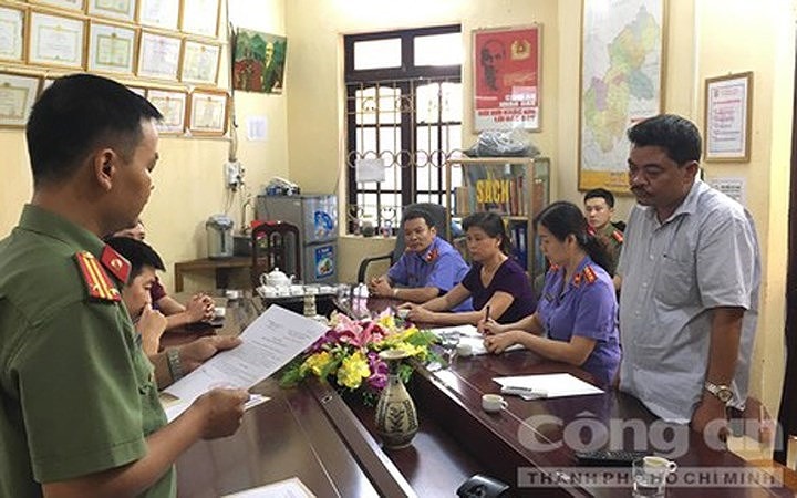 Sau đó 3 ngày, Công an tỉnh Hà Giang ra quyết định khởi tố bị can, bắt bị can để tạm giam 3 tháng đối với ông Nguyễn Thanh Hoài (Trưởng phòng Khảo thí và Kiểm định chất lượng Sở GD&ĐT Hà Giang) về tội Lợi dụng chức vụ, quyền hạn trong khi thi hành công vụ. Trong ảnh: Cơ quan điều tra đọc lệnh khởi tố đối với ông Hoài đang đứng, mặc áo trắng. (Ảnh: Báo Công an TP HCM).