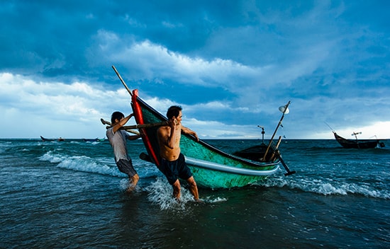 Ngư dân đưa thuyền lên bờ.