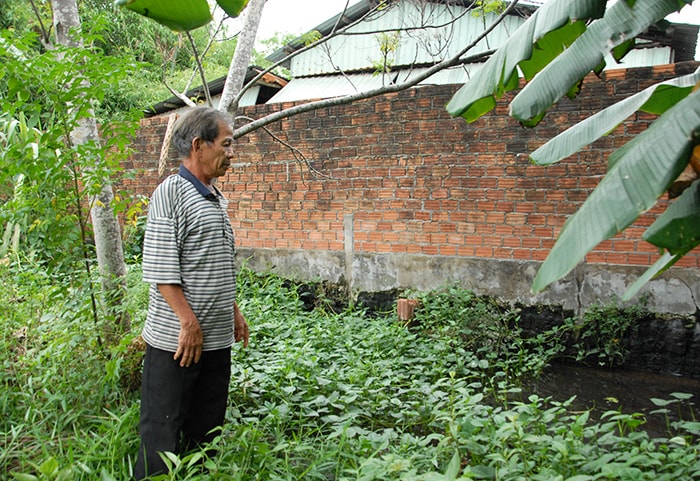 Trại chăn nuôi của ông Trần Công Kiên nằm ngay giữa khu dân cư, nước có màu đen kịt và bốc hôi thối.. Ảnh: H.Q