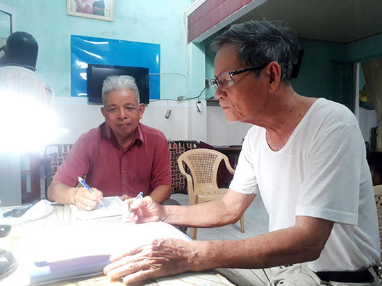 Ông Nguyễn Quang Vinh (phải) và ông Lê Hữu Cát ghi chép danh sách cá nhân, tổ chức đóng góp cho quỹ nạn nhân chất độc da cam.Ảnh T.Q