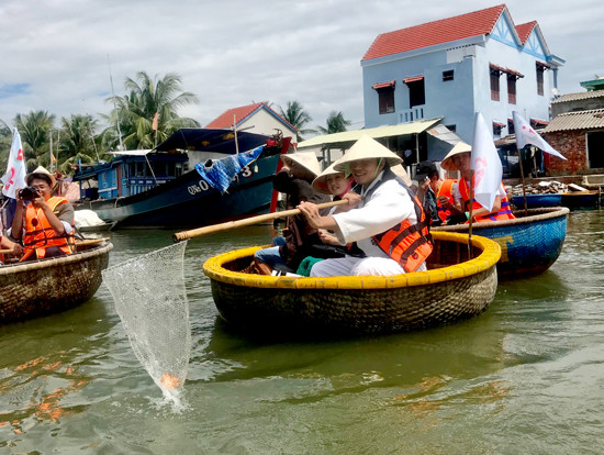 A Japanese delegation fishing waste out of in Bay Mau nipa forest