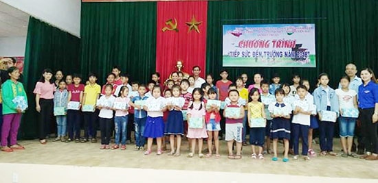 Thanh niên xã Hiệp Thuận trao quà cho học sinh mồ côi, khuyết tật. Ảnh: T.HÒA