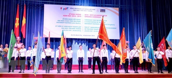 Nghi thức trao cờ truyền thống chào đón tân sinh viên. (Ảnh: Thu Hoài/TTXVN)