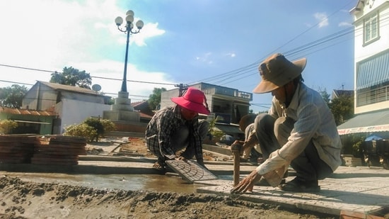 Các chi hội, đoàn thể lắp gạch hoa, trồng cây xanh trang trí ngã ba thôn Bình Hòa. Ảnh: HỒ QUÂN