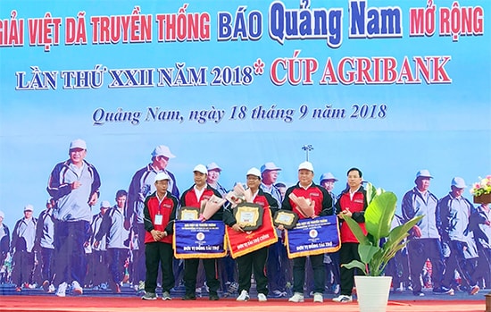 Nhà báo Lê Văn Nhi - Tổng Biên tập Báo Quảng Nam tặng hoa các đơn vị tài trợ.