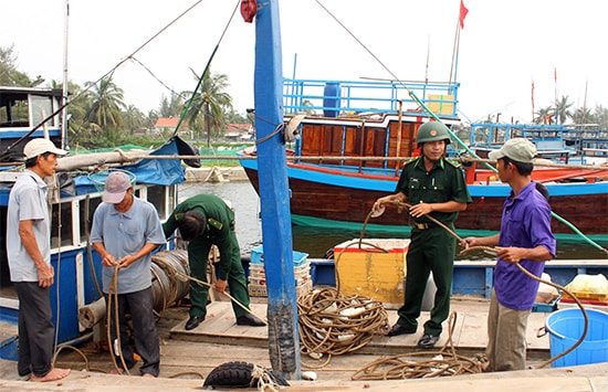 Cán bộ, chiến sĩ Bộ đội Biên phòng động viên ngư dân yên tâm bám biển.Ảnh: B.Q.N