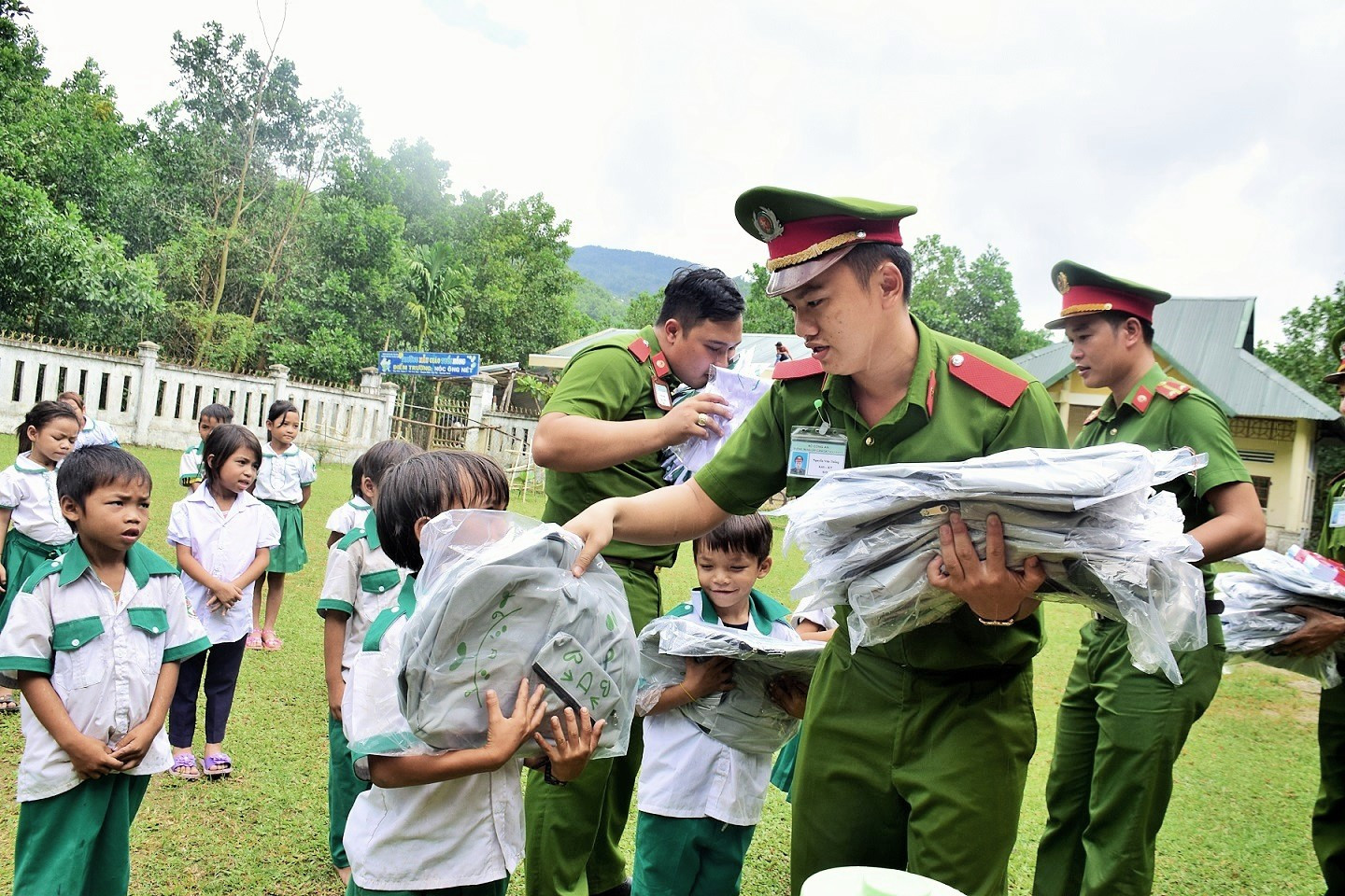 Các học viên Trường Trung cấp Cảnh sát nhân dân V tặng quà cho các em học sinh Trường Tiểu học Nông Văn Dền (xã Trà Bui). Ảnh: THANH THẮNG