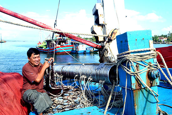 Ngư dân Phạm Xuân Anh sửa lại vàng lưới vây ánh sáng để chuẩn bị đi biển. Ảnh: QUANG VIỆT