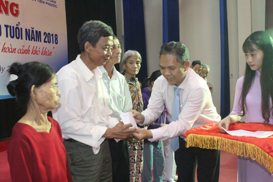 Phó Chủ tịch UBND huyện Tiên Phước Phùng Văn Huy tặng quà cho người cao tuổi khó khăn. Ảnh: D.L