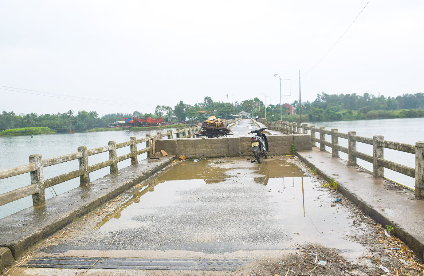 Để tránh người dân đi lại trên cầu, UBND xã Duy Vinh đã đỗ bê tông cao hơn 0.5m và đặt biển cấm qua cầu. Tuy nhiên do quản đường đi lại qua cầu tạm xa nên nhiều người di chuyển bằng xe đạp vẫn bấp chấp qua cầu. Ảnh: THANH THẮNG