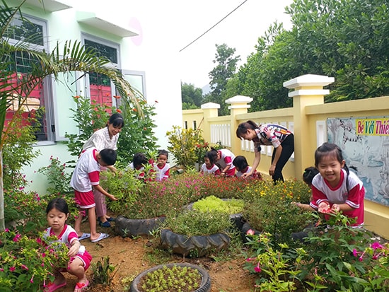 Cô và trò Trường Mẫu giáo Hương Sen (huyện Nông Sơn) khám phá môi trường vườn hoa của bé. Ảnh: THIÊN THU