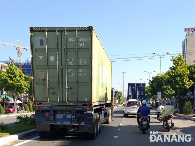 Nhằm hạn chế tai nạn giao thông, người điều khiển xe máy không nên chạy song song hoặc chạy trước đầu xe container.     Ảnh: AN NHIÊN