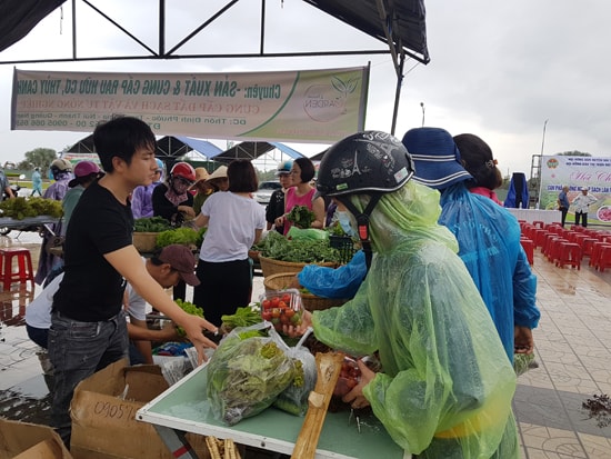 Người dân mua rau sạch được nông dân bán tại hội chợ. Ảnh: D.L