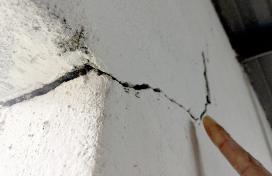 Các vết nứt khiến tường nhà bị thấm vào mỗi ngày mưa. Ảnh: PHAN VINH