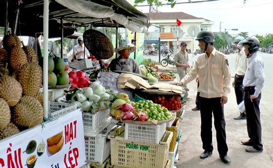 Quầy hàng trái cây lấn chiếm hết vỉa hè dành cho người đi bộ. Ảnh: PHAN VINH