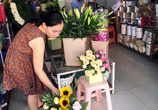 Chị Dung Hòa (chủ shop hoa Daksa, đường Trưng Nữ Vương, TP. Tam Kỳ) đang chuẩn bị hoa cho khách. Ảnh: KIỀU LY