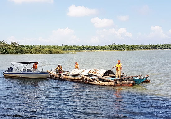 Lực lượng Cảnh sát đường thủy vận chuyển số gỗ tang vật bắt giữ được vào sáng 20.10 bàn giao cho cơ quan chức năng. Ảnh: T.C