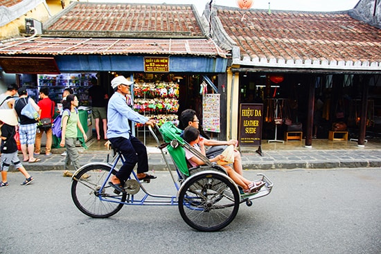 Du khách dạo phố cổ bằng xe xích lô.  Ảnh: PHƯƠNG THẢO