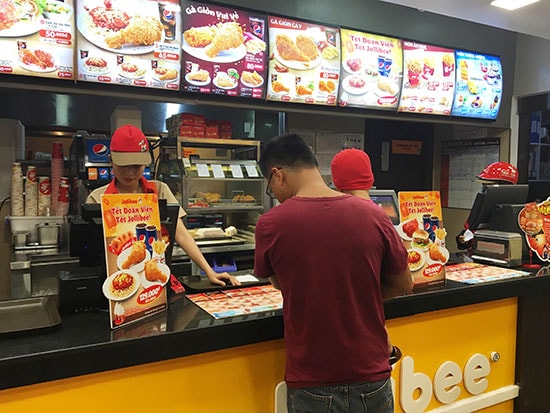 Khách hàng chọn mua sản phẩm tại cửa hàng thức ăn nhanh Jollibee (siêu thị Co.opMart, TP.Tam Kỳ). Ảnh: K.L