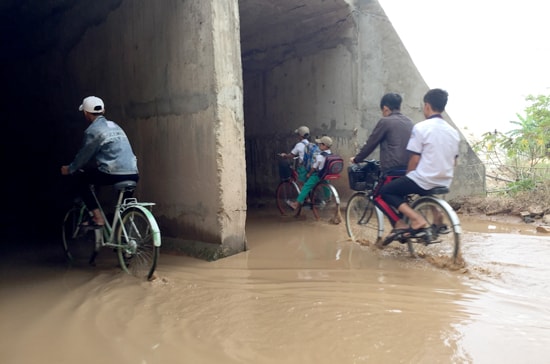 Các em học sinh thường xuyên đi qua đoạn đường này. Ảnh: PHAN VINH