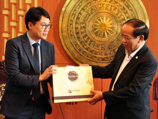 Director Sungnnung Lee (left) offers a gift (South Korean ginseng) to Chairman Thu. 
