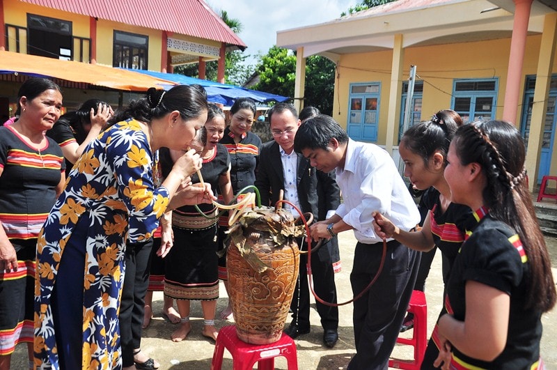 Đại biểu và bà con cùng thường thức rượu cần truyền thống. Ảnh: VINH ANH