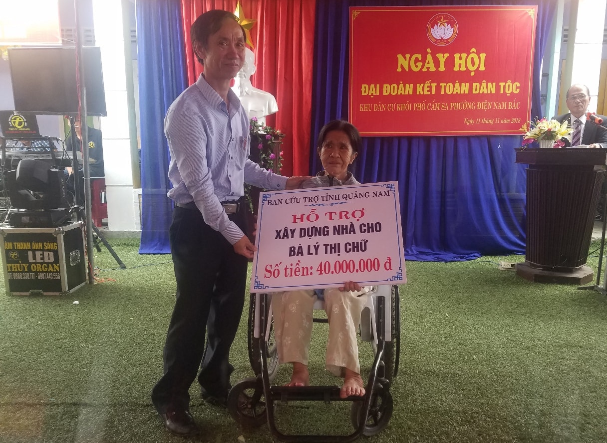 Đồng chí Võ Hồng tặng bảng tượng trưng số tiền 40 triệu đồng cho bà Huỳnh Thị Chữ. Ảnh: Q.T