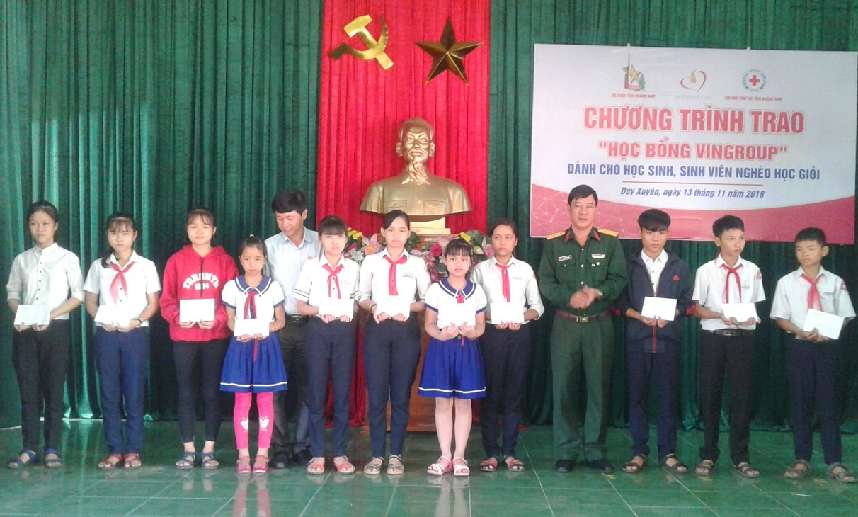 Đại diện các đơn vị liên quan trao “học bổng VinGroup” cho các em học sinh. Ảnh: VĂN SỰ 