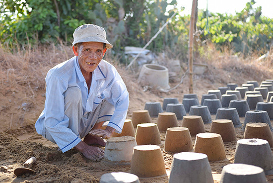 Cụ Trình, 70 tuổi là người phụ đúc chậu cùng anh em anh Máy.