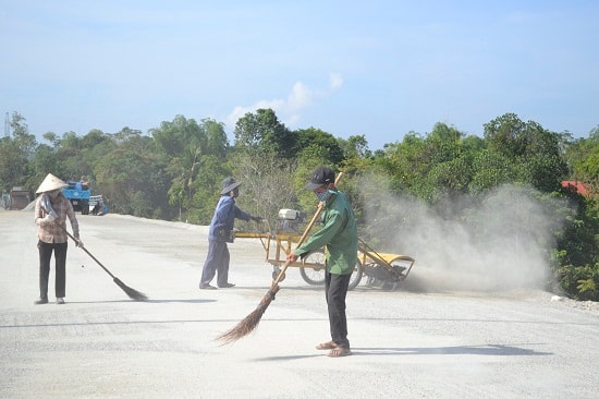 Thổi bụi, vệ sinh bề mặt cấp phối đá dăm trước khi tưới nhũ tương và thảm bê tông nhựa. Ảnh: CT