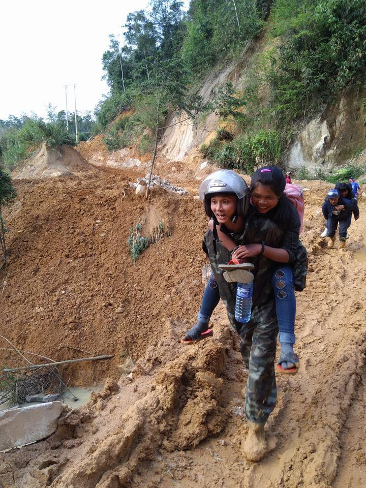 Thầy Nguyễn Hồng Rin, giúp học sinh vượt qua đoạn đường lầy lội trong chuyến đi thi học sinh giỏi cấp huyện. Ảnh : KL