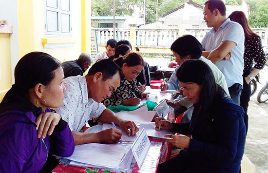 Người dân thôn Phước Châu (Bình Triều) điền trực tiếp vào phiếu đánh giá. Ảnh: Biên Tân