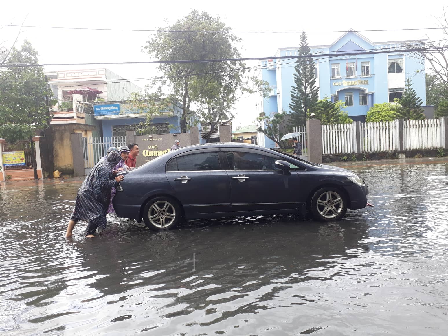 Nhiều người dân phải đây ô tô qua đoạn ngập nước tại đường Phan Bội Châu. Ảnh: THANH THẮNG