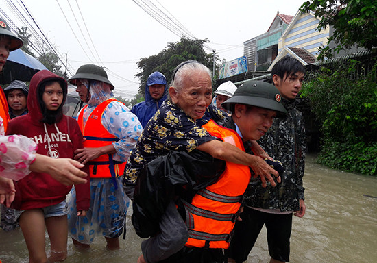  Ảnh 5: Trong sáng 10.12, đã có trên 20 người già và trẻ em được lực lượng cứu hộ đưa ra khỏi những ngôi nhà đã chìm sâu trong nước lũ.