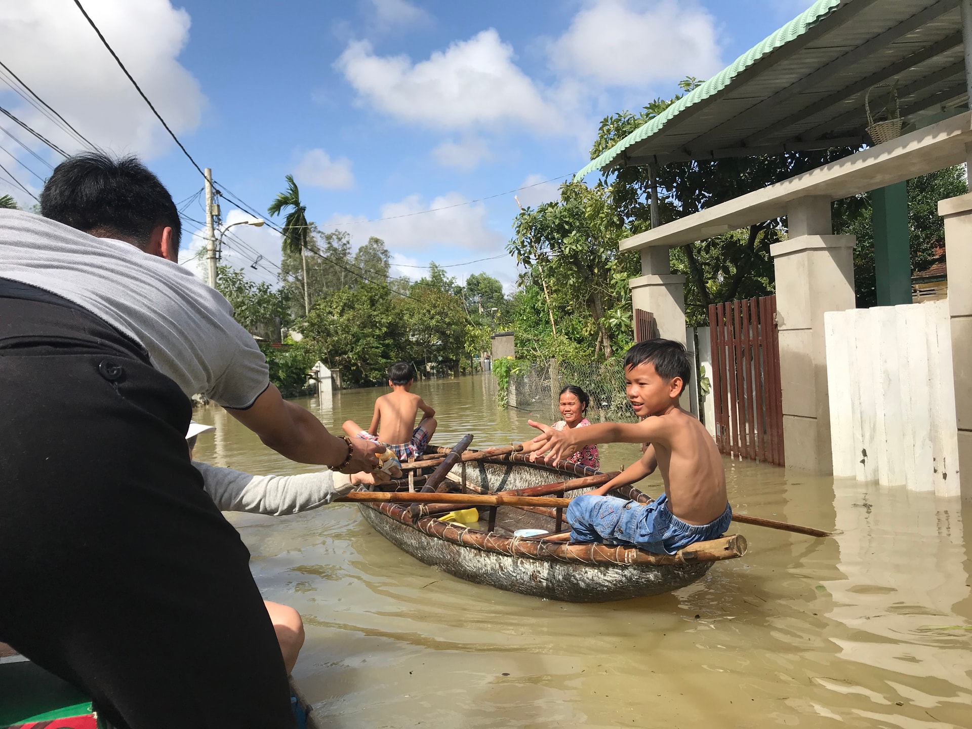 Trẻ em khối phố Đoan Trai bơi ghe ra nhận đồ cứu trợ. Ảnh: VINH ANH