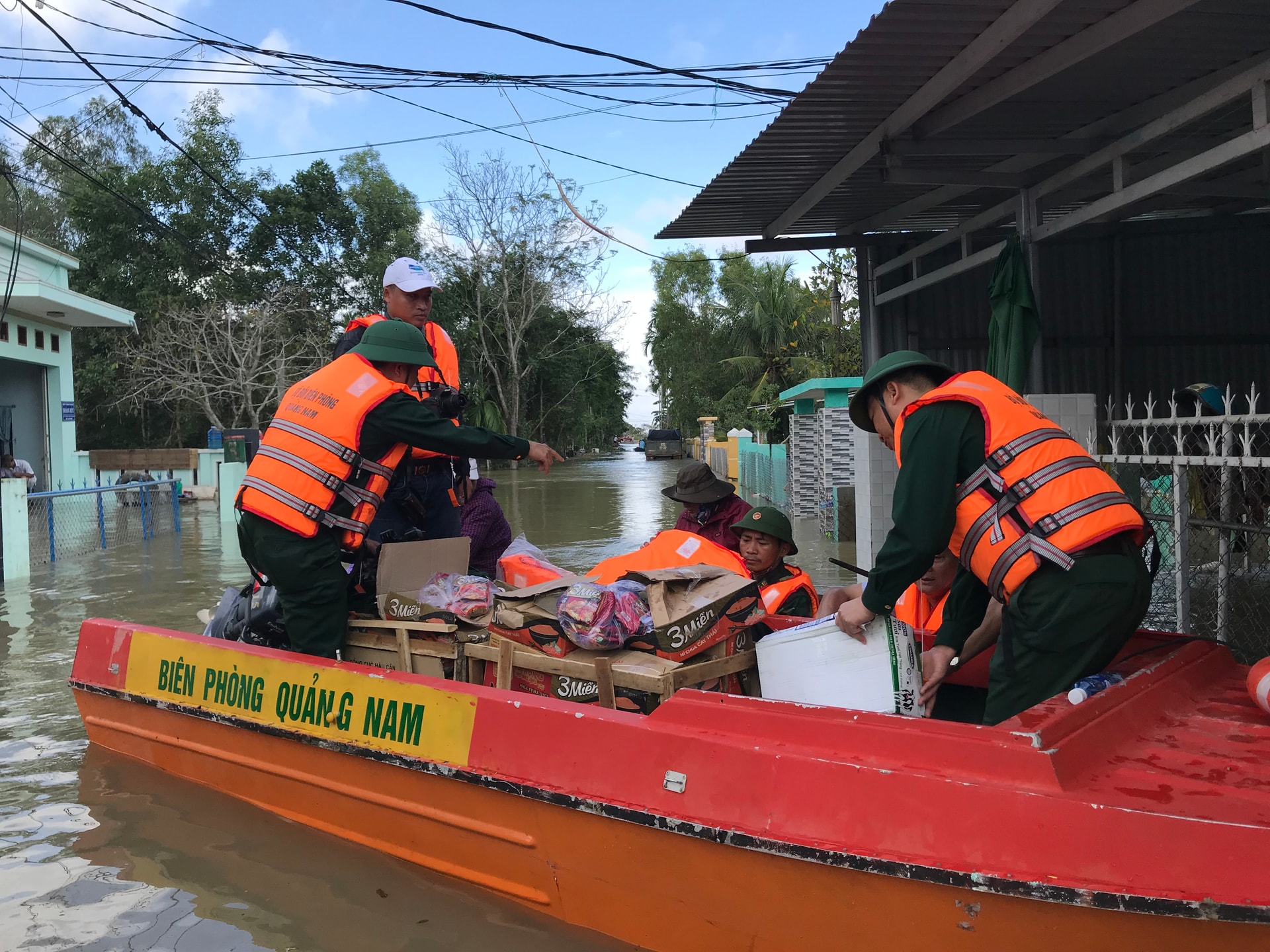 Trẻ em khối phố Đoan Trai bơi ghe ra nhận đồ cứu trợ. Ảnh: VINH ANH