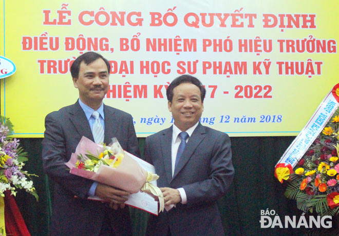 PGS.TS Nguyễn Ngọc Vũ (phải), Giám đốc Đại học Đà Nẵng trao quyết định và tặng hoa cho tân Phó Hiệu trưởng Trường Đại học Sư phạm kỹ thuật, Đại học Đà Nẵng.