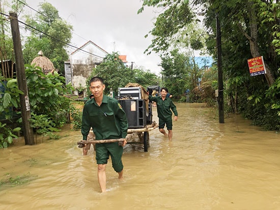 Các thành viên tổ tự quản giúp dân di dời đồ đạc trong đợt mưa lũ vừa qua. Ảnh: L.T