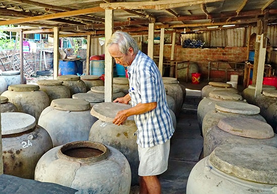 Ông Lê Văn Ngọc, thôn Trung Thanh, (xã Tam Thanh) giới thiệu những lu mắm đã chín. Ảnh: N.Đ.N