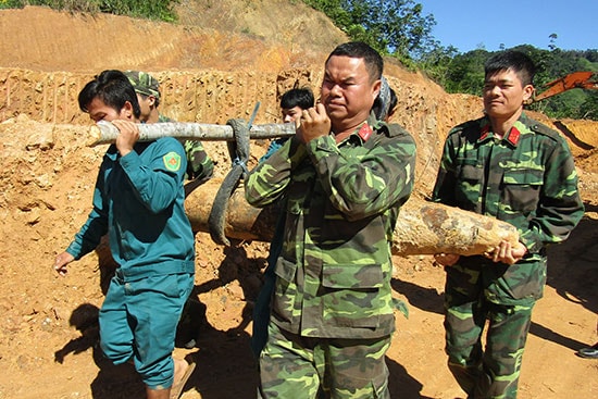 Đại úy Mạc Văn Xuân (ngoài cùng bên phải) cùng đồng đội tham gia công tác rà phá bom mìn. Ảnh: Đ.N