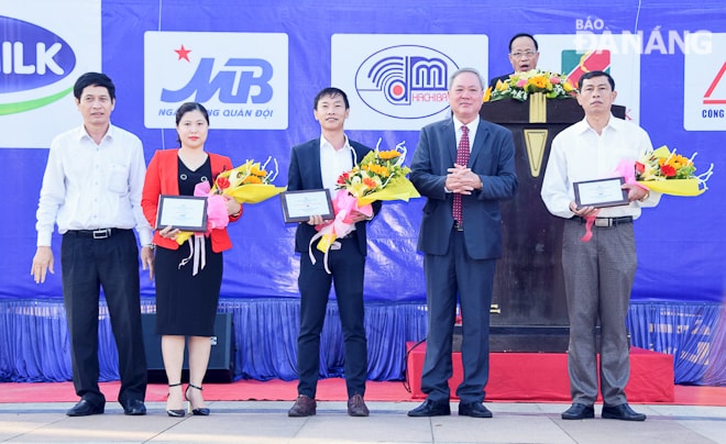 Tổng Biên tập Báo Đà Nẵng Trương Công Định, Trưởng Ban Tổ chức giải (thứ 2, phải sang) và Giám đốc Sở Văn hóa & Thể thao Huỳnh Văn Hùng (thứ nhất, bên trái) tặng hoa và kỷ niệm chương cho các nhà tài trợ.