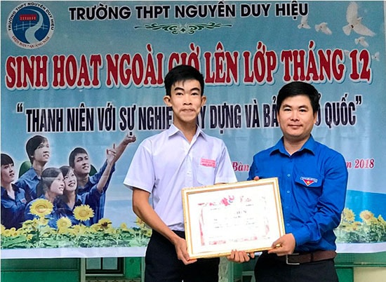 Anh Lê Quang Quỳnh - Phó Bí thư Tỉnh đoàn trao bằng khen cho Nguyễn Tấn Hiếu (trái). Ảnh: VINH ANH