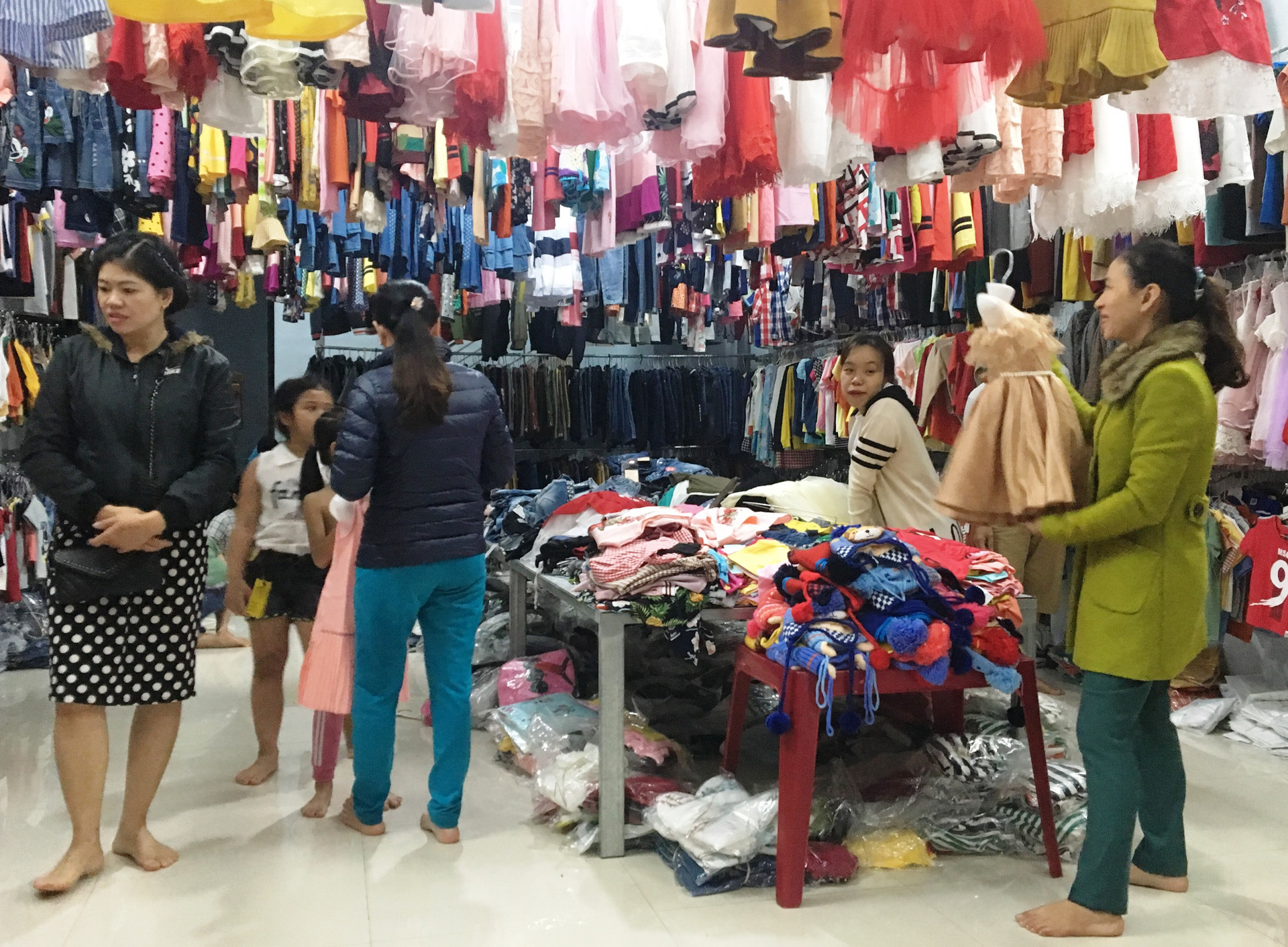 Khách hàng lựa chọn quần áo tại của hàng Thu Sương (chợ Thương mại, TP. Tam Kỳ). Ảnh: KL