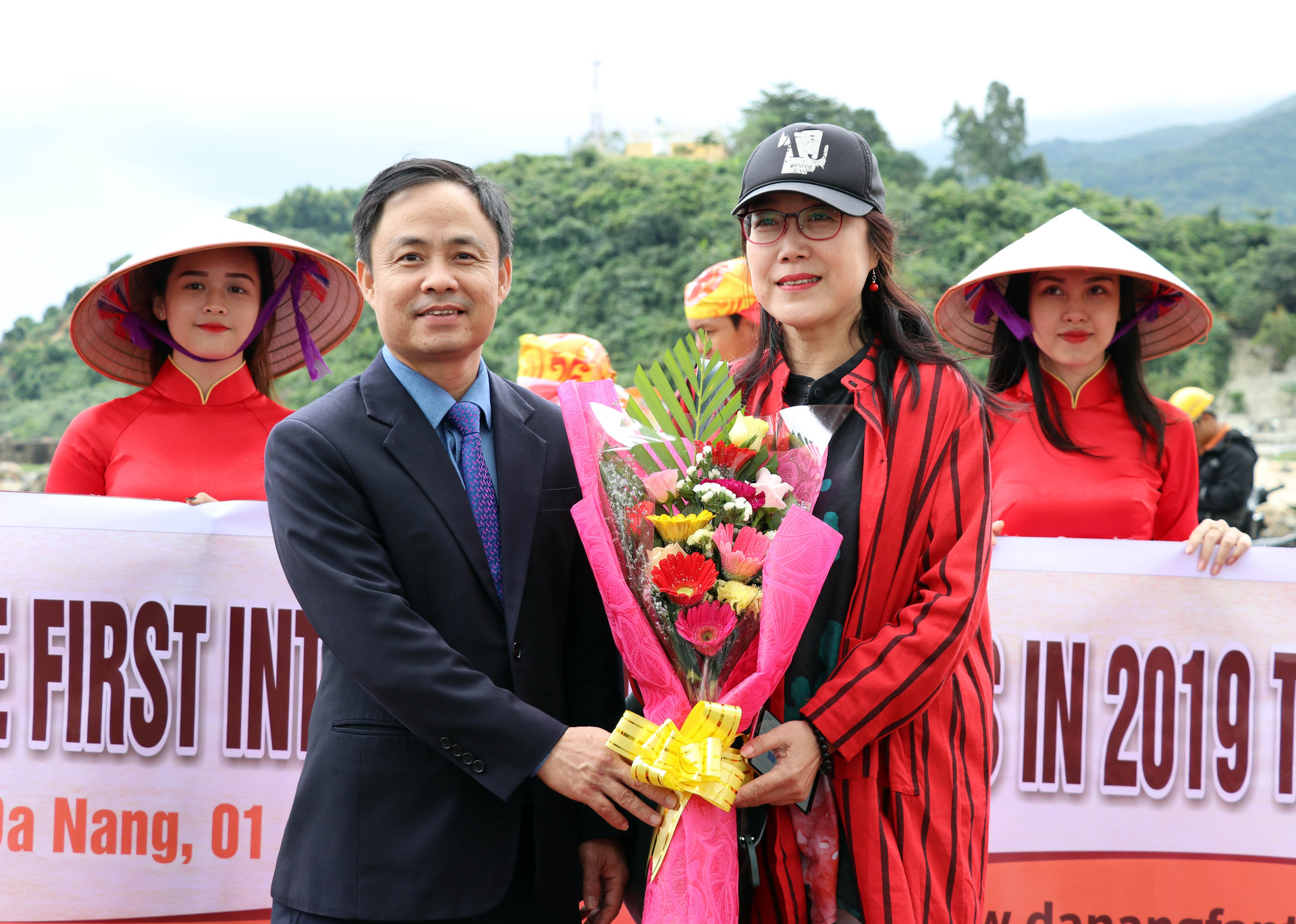 Tặng hoa cho một trong những du khách đầu tiên đặt chân đến Đà Nẵng. X.L