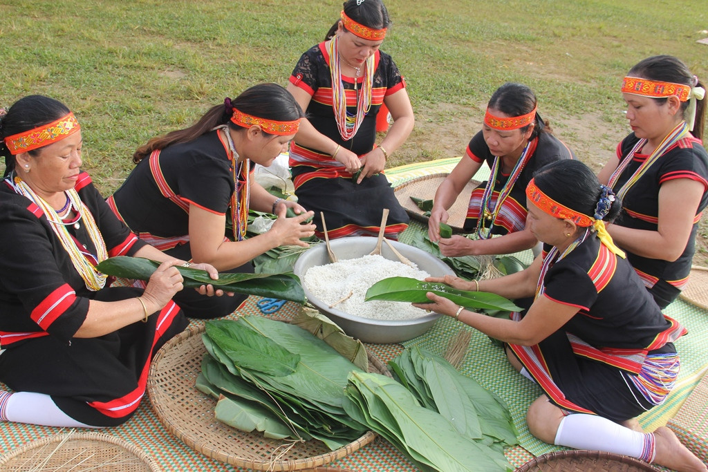 Xen giữa nhịp cồng chiêng rộn rã, các phụ nữ Bh noong cùng nhau gói từng cặp bánh sừng trâu, bánh ốc phục vụ lễ hội. Ảnh: A.N