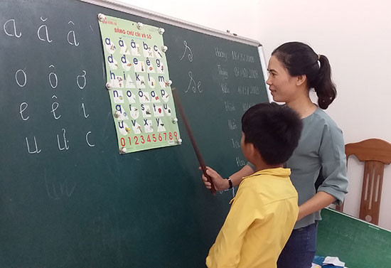 Cô giáo đang dạy cho trẻ khuyết tật là cán bộ Hội LHPN xã Bình Minh. Ảnh: BIÊN TÂN