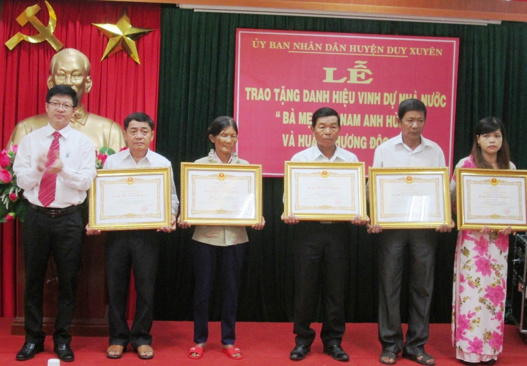 Lãnh đạo huyện Duy Xuyên trao danh hiệu Bà mẹ Việt Nam anh hùng cho thân nhân các mẹ.  Ảnh: H.N