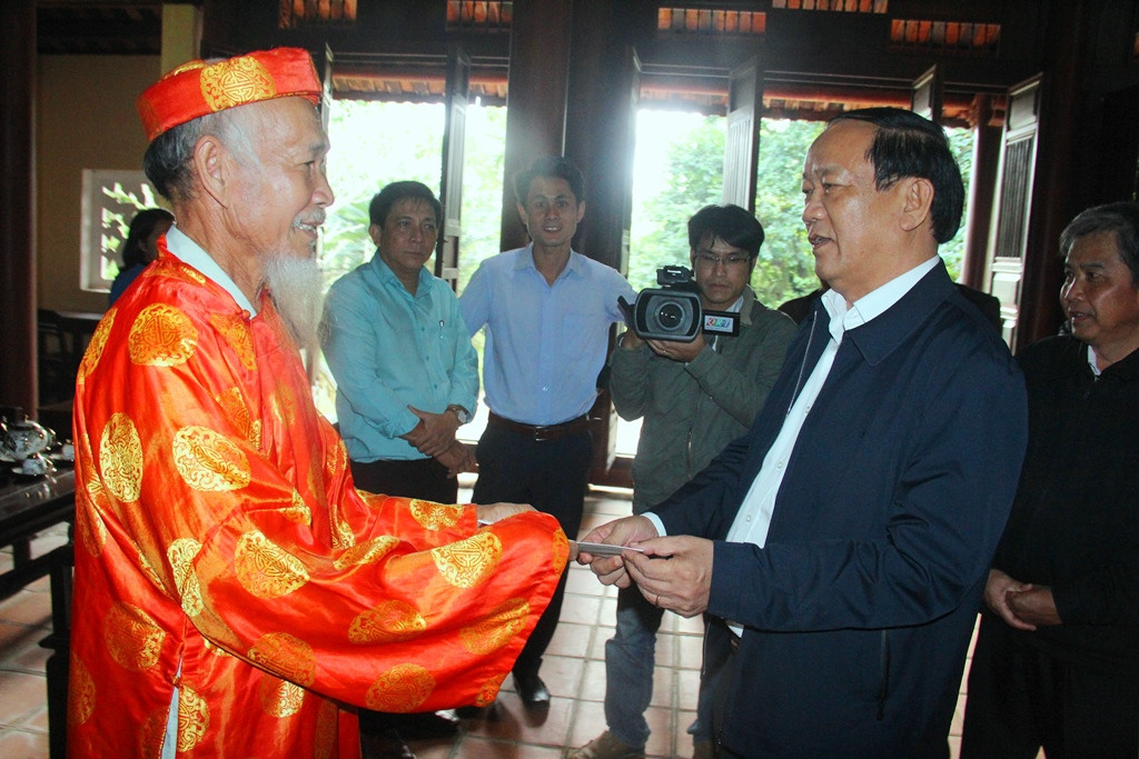 Chủ tịch UBND tỉnh Đinh Văn Thu động viên và trao quà cho ông Phân Ngấu - người trông coi Nhà lưu niệm cụ Phan Châu Trinh. Ảnh: A.N